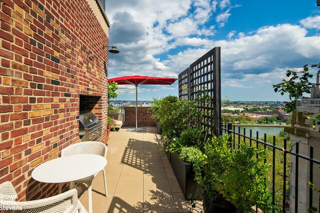 view of patio featuring a grill and a water view