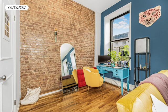 office area featuring hardwood / wood-style floors and brick wall