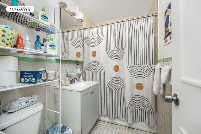 bathroom featuring tile patterned floors, vanity, toilet, and curtained shower