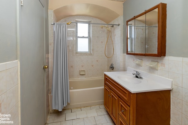 bathroom featuring shower / tub combo with curtain, vanity, tile patterned floors, and tile walls