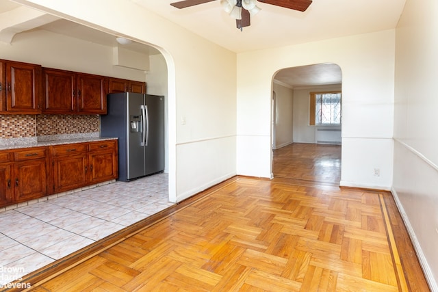 kitchen with ceiling fan, stainless steel fridge, decorative backsplash, and light parquet floors