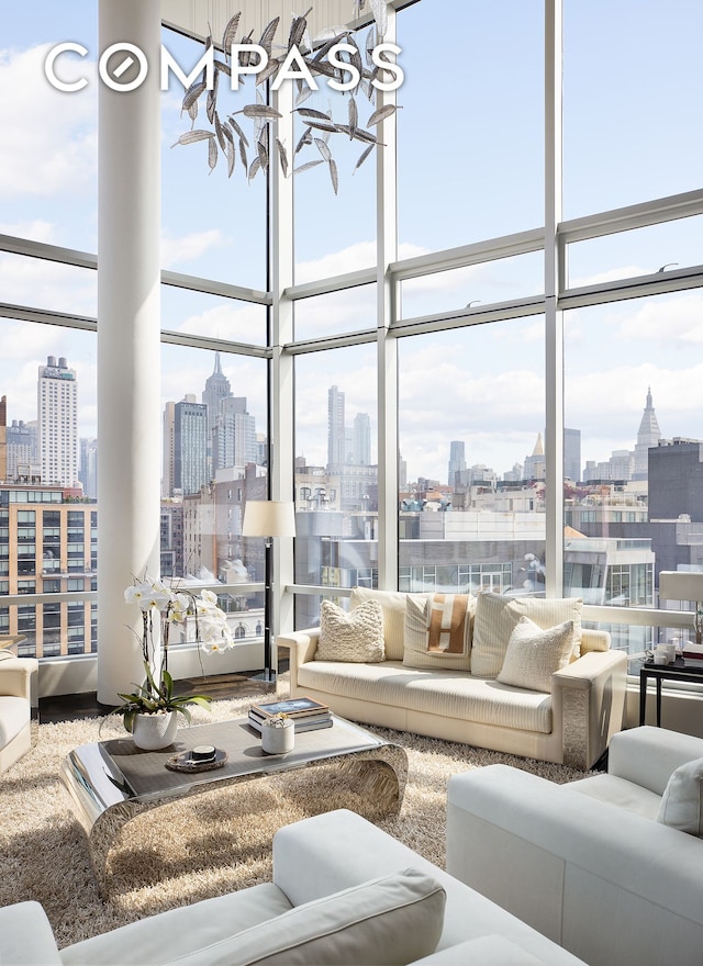 living area with a wealth of natural light, a city view, and a wall of windows