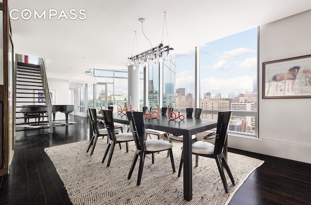 dining space with an inviting chandelier, stairs, dark wood-type flooring, expansive windows, and a view of city