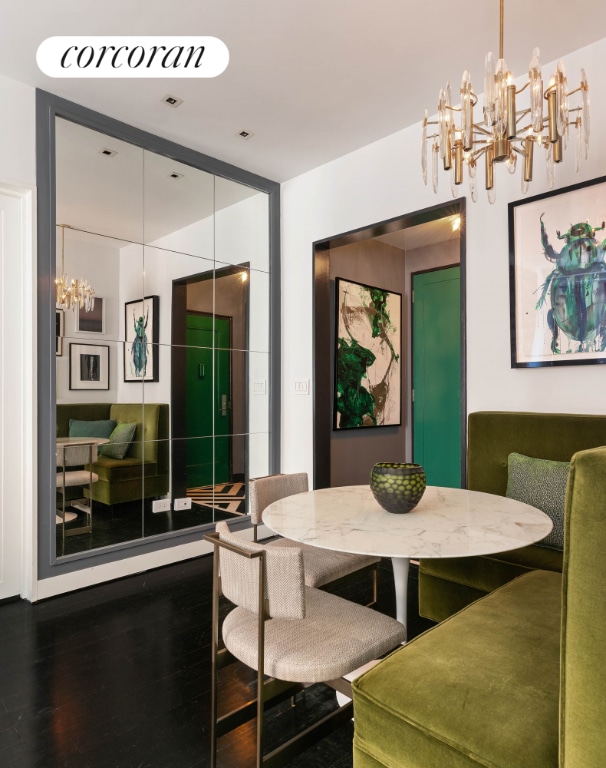 dining space featuring dark wood-style floors and a notable chandelier