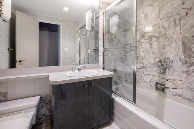 full bathroom featuring enclosed tub / shower combo, vanity, and toilet