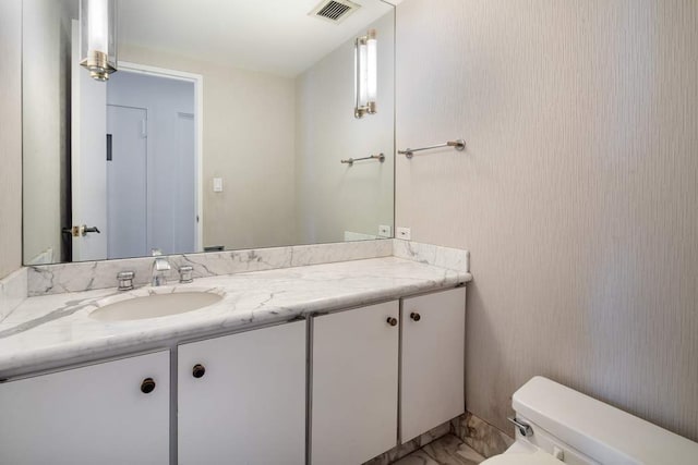 bathroom featuring vanity and toilet