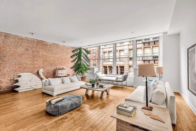 living room with brick wall and hardwood / wood-style floors