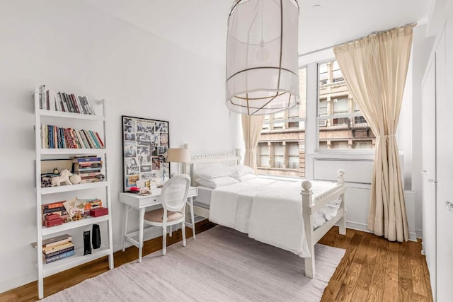 bedroom with hardwood / wood-style flooring and a notable chandelier