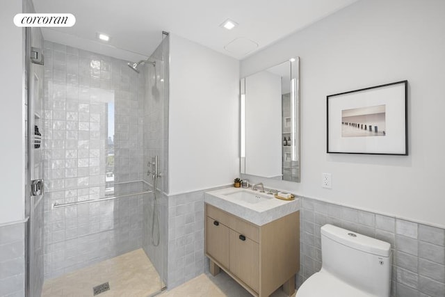 bathroom featuring vanity, toilet, an enclosed shower, and tile walls