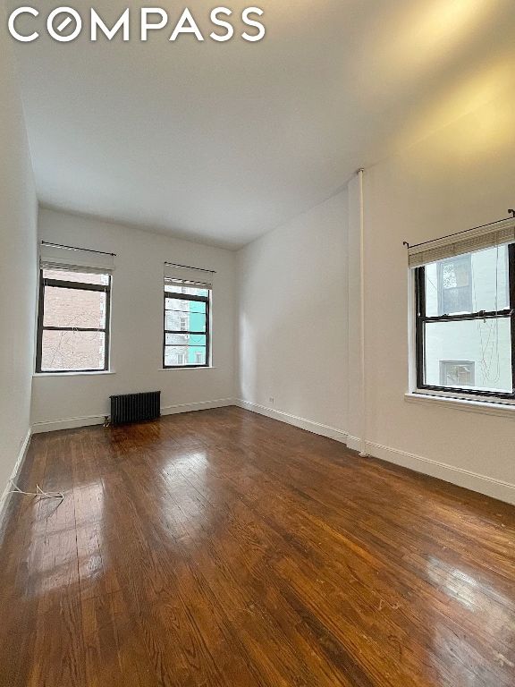 empty room with dark hardwood / wood-style flooring