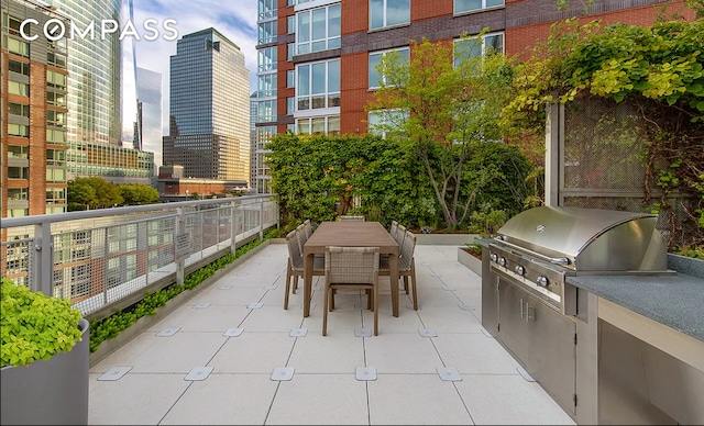 view of patio featuring exterior kitchen, a view of city, grilling area, and outdoor dining space