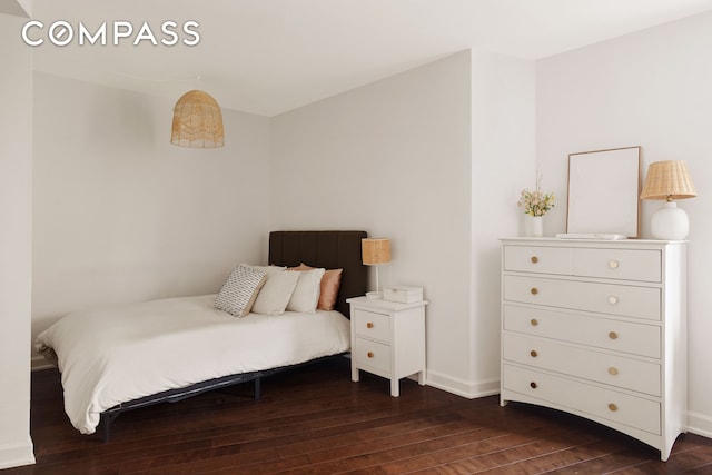 bedroom featuring baseboards and dark wood-type flooring