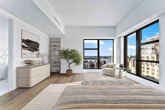 bedroom featuring a water view and light hardwood / wood-style flooring