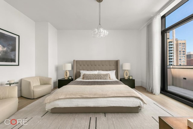 bedroom with hardwood / wood-style floors and a chandelier