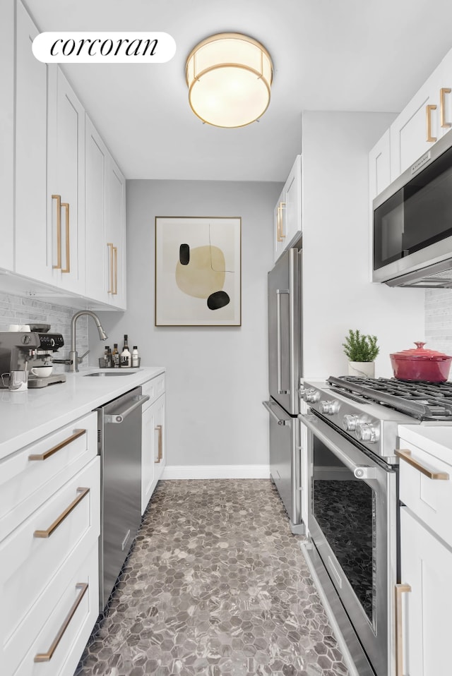 200 E 94th St Unit 603, New York City, NY 10128 - kitchen featuring stainless steel appliances, decorative backsplash, white cabinets, light countertops, and stone finish flooring