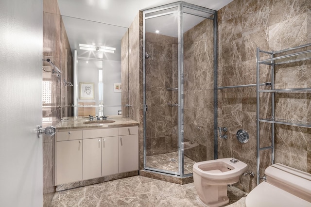 bathroom featuring toilet, a bidet, a shower stall, and vanity