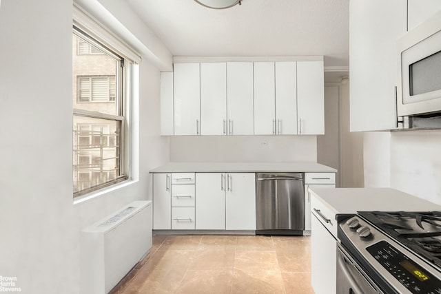 kitchen featuring white cabinetry, stainless steel appliances, and radiator