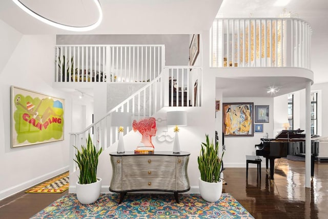 entryway with hardwood / wood-style floors and a towering ceiling