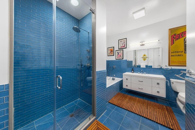 full bathroom with shower with separate bathtub, tile walls, tile patterned flooring, vanity, and toilet