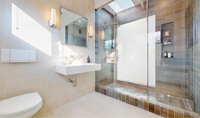 bathroom featuring tile walls, sink, toilet, and a tile shower