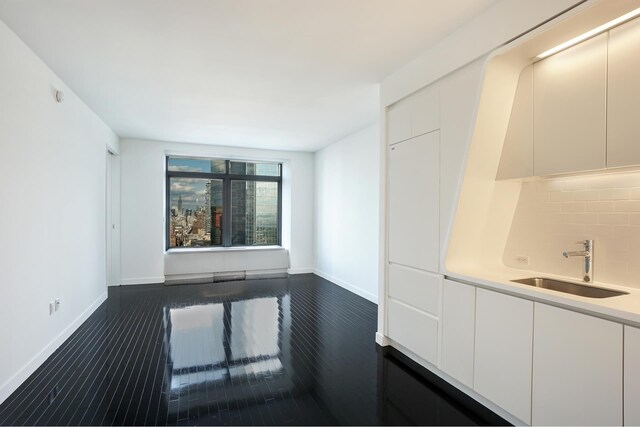 unfurnished room featuring dark hardwood / wood-style floors and sink