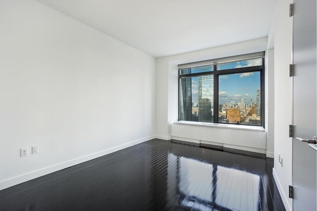 empty room with dark hardwood / wood-style flooring