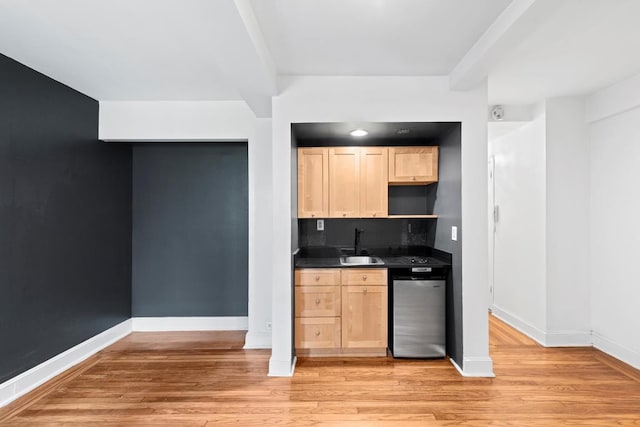 kitchen with dishwasher, sink, light brown cabinetry, and light hardwood / wood-style flooring