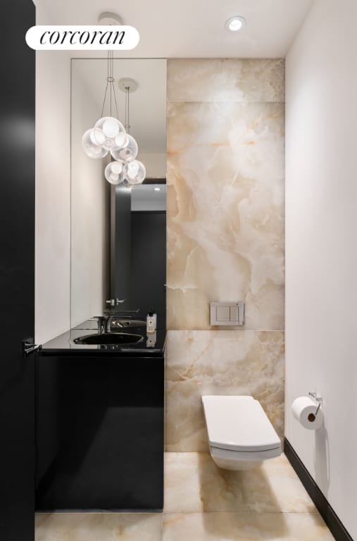 bathroom with tile walls, vanity, and toilet