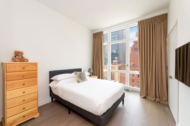 bedroom featuring dark hardwood / wood-style flooring and multiple windows