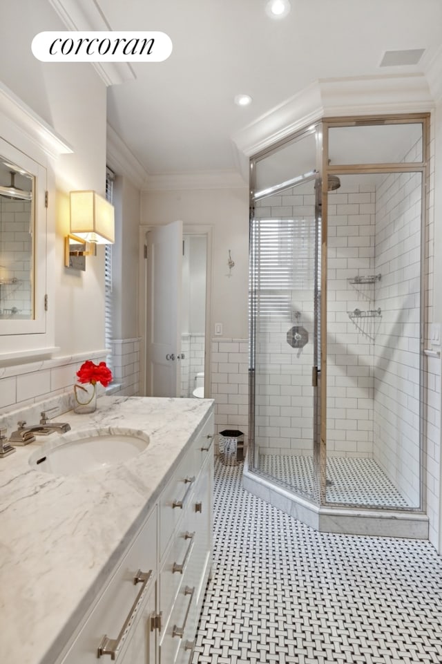 full bathroom with a stall shower, crown molding, vanity, and recessed lighting