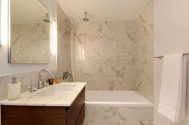 full bathroom with a combined bath / shower with rainfall shower, tile walls, and vanity