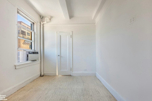 spare room with cooling unit and beamed ceiling