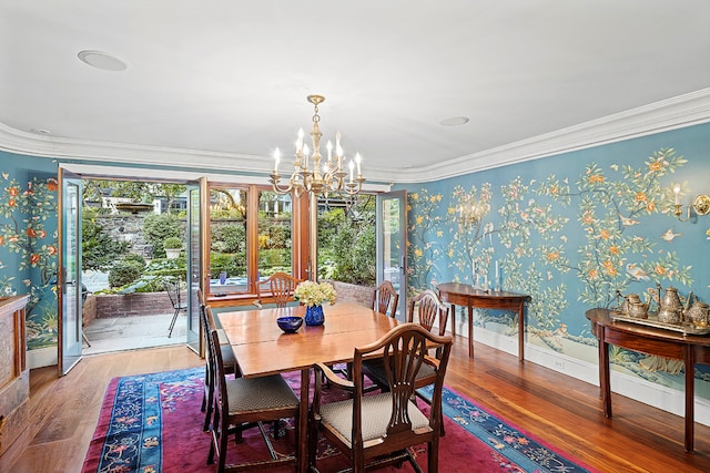 dining room featuring ornamental molding, hardwood / wood-style floors, and a notable chandelier