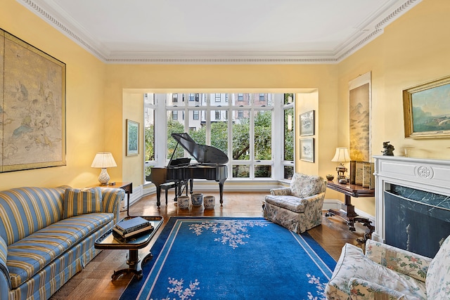 living area featuring a fireplace, ornamental molding, and wood-type flooring