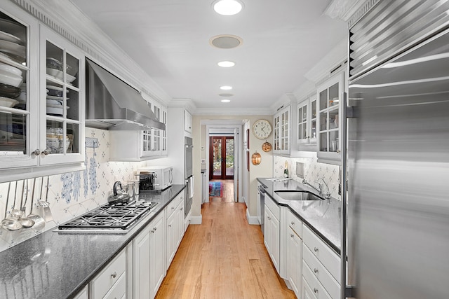 kitchen with stainless steel appliances, sink, dark stone countertops, and white cabinets