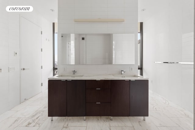 bathroom featuring vanity and tile walls