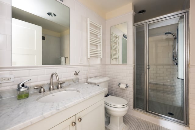 bathroom featuring radiator, tile walls, vanity, an enclosed shower, and toilet