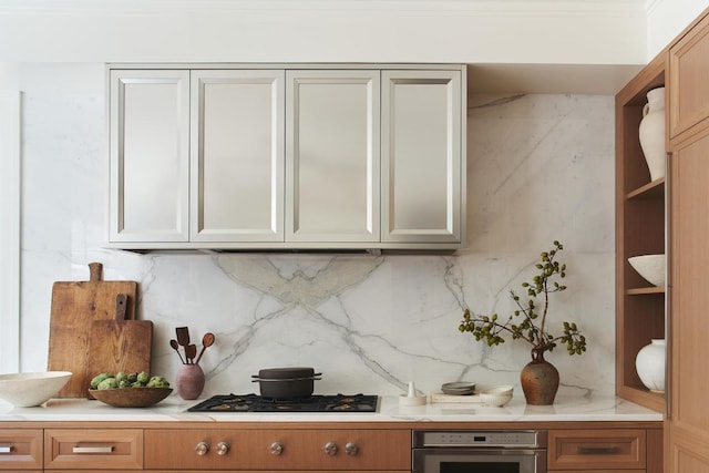 kitchen with gas stovetop, stainless steel oven, and tasteful backsplash