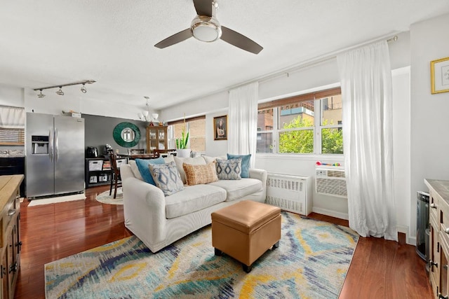 living room with radiator, wood-type flooring, and ceiling fan with notable chandelier