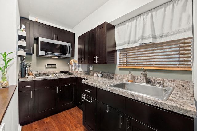 kitchen with dark wood-style floors, stainless steel appliances, a sink, and light countertops