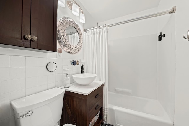 bathroom featuring vanity, shower / bath combination with curtain, toilet, and tile walls