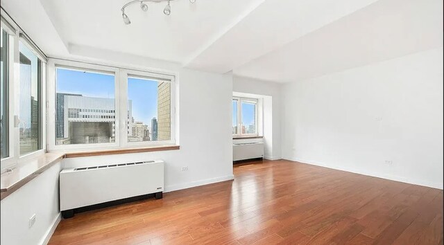 425 5th Ave Unit 40-A, New York City, NY 10016 - unfurnished room featuring radiator, wood finished floors, and baseboards