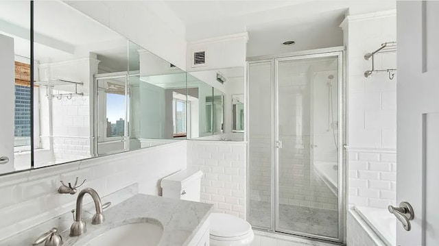 bathroom featuring vanity, a shower with shower door, tile walls, and toilet