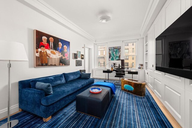 living room with crown molding, wood-type flooring, and built in features