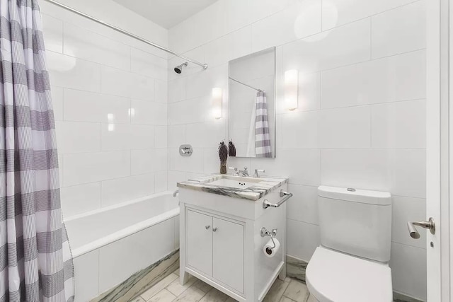 bathroom featuring vanity, marble finish floor, toilet, tile walls, and shower / tub combo
