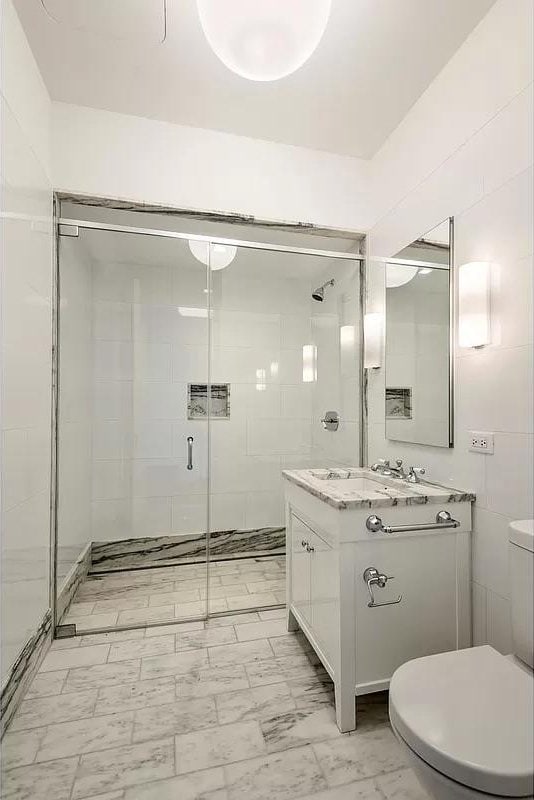 bathroom with vanity, marble finish floor, a stall shower, and toilet