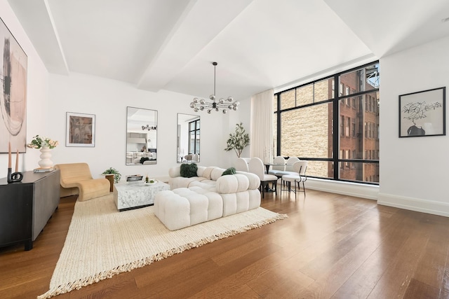 living room with baseboards, a chandelier, and wood finished floors