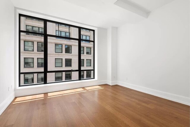 empty room featuring baseboards and wood finished floors