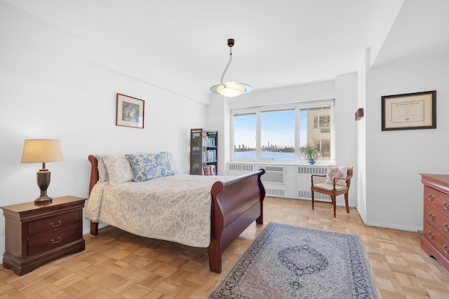 bedroom with radiator, a water view, and baseboards