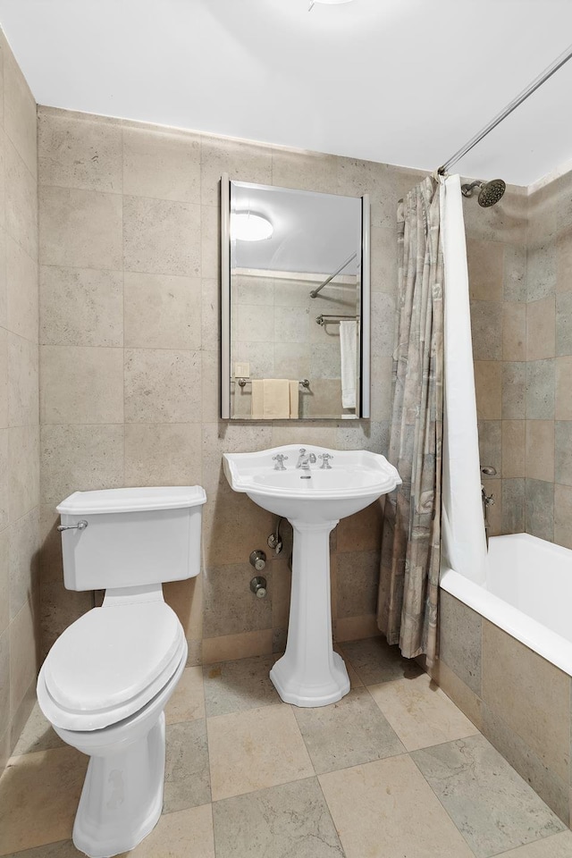 full bathroom featuring toilet, tile walls, and tiled shower / bath combo